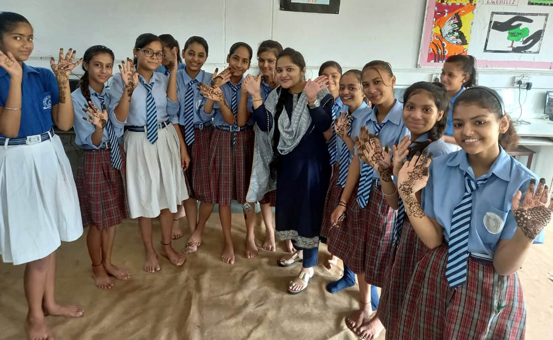 In summer camp, girls put mehndi on their hands