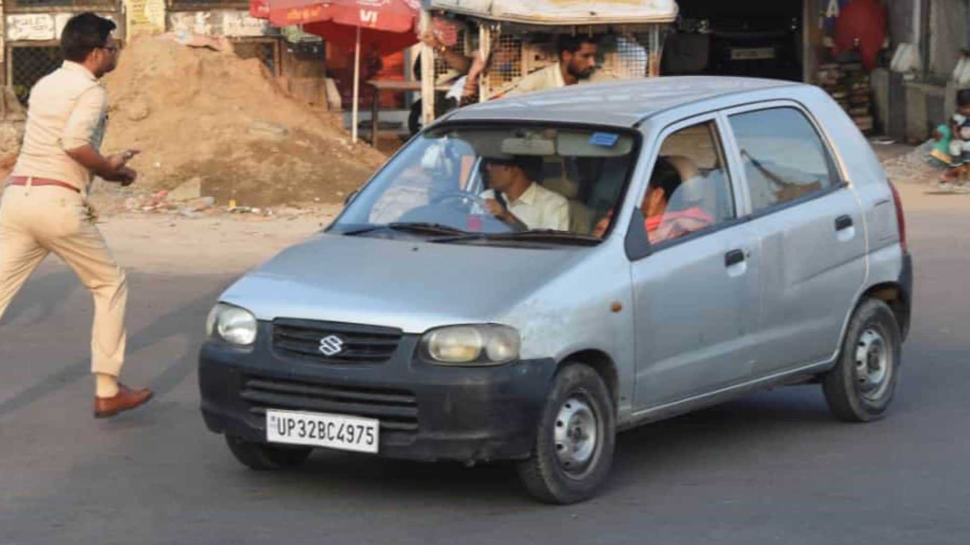 A police man takes action against an e rickshaw driver and leaves car.