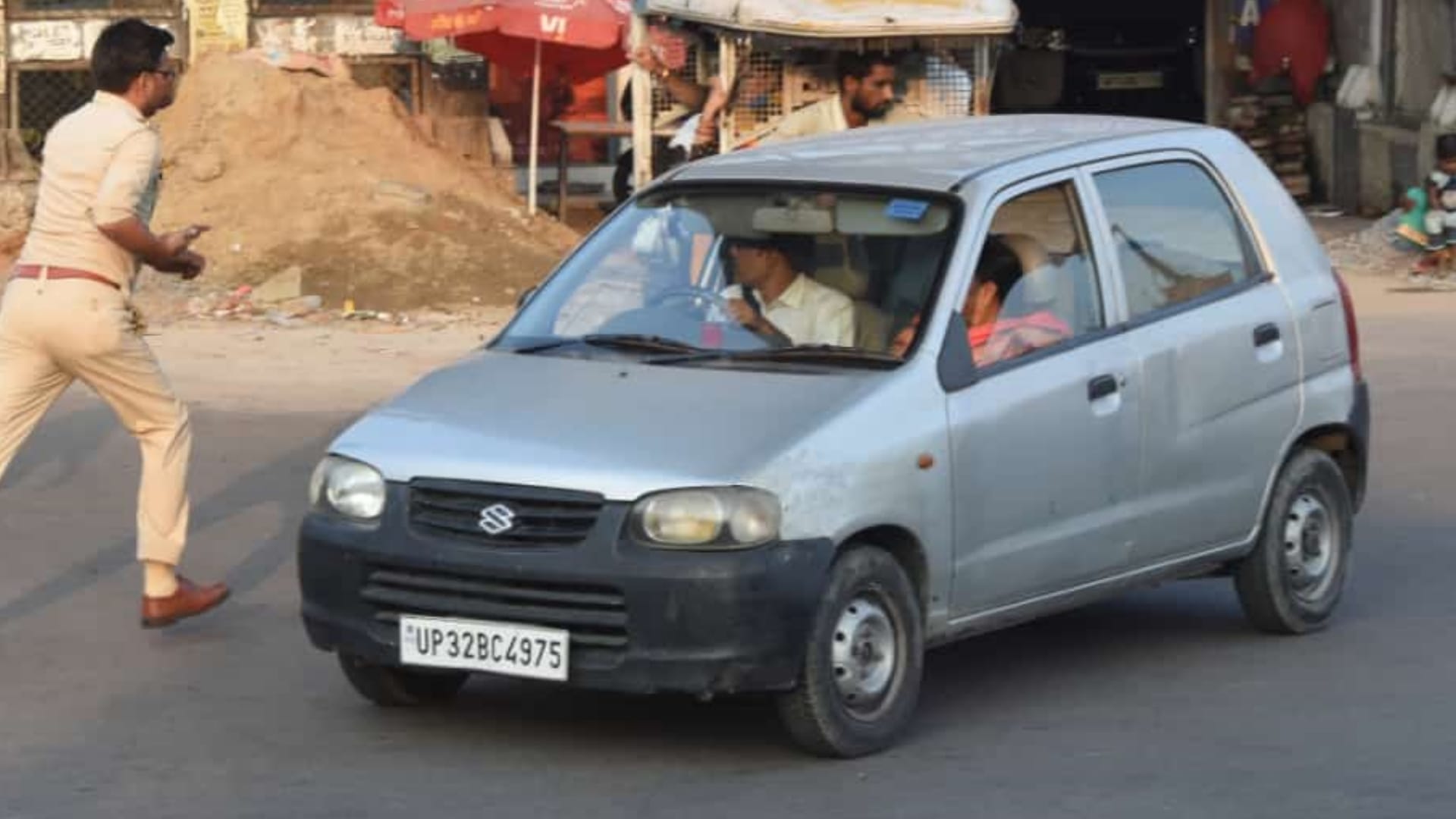 A police man takes action against an e rickshaw driver and leaves car.