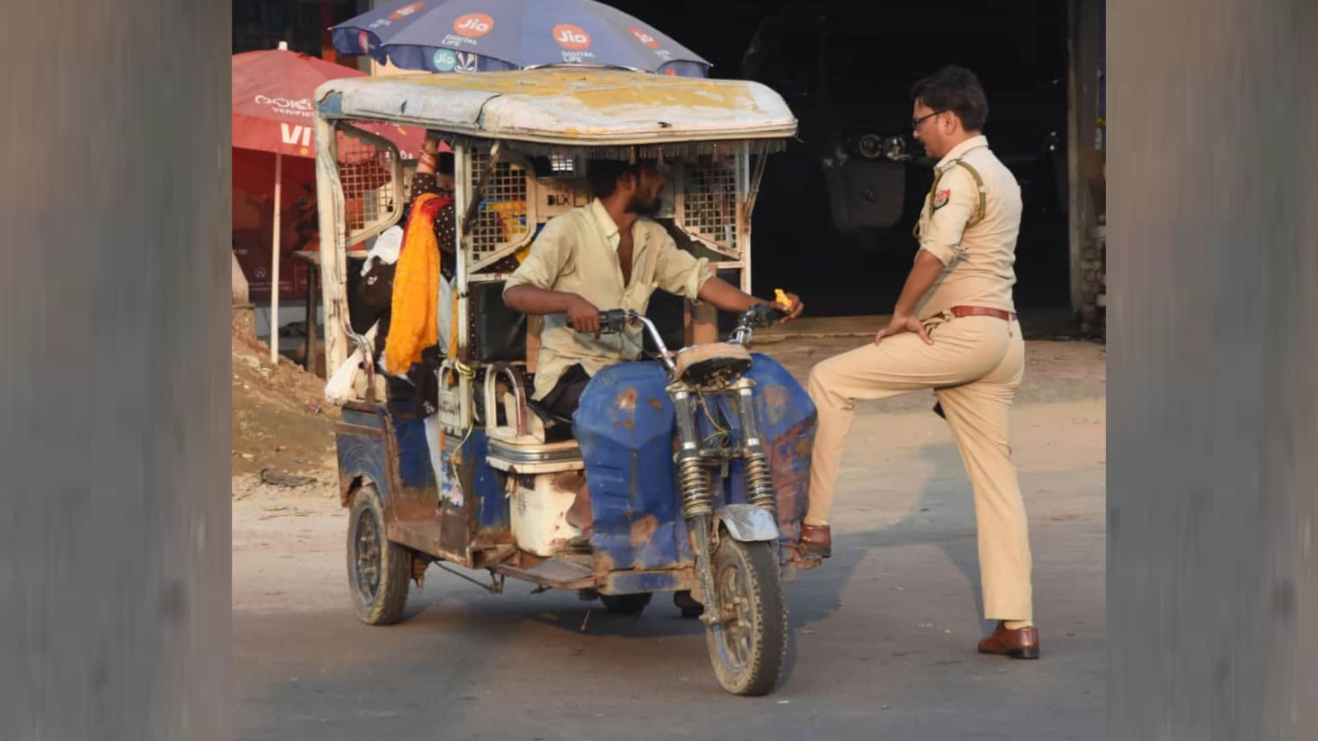 A police man takes action against an e rickshaw driver and leaves car.