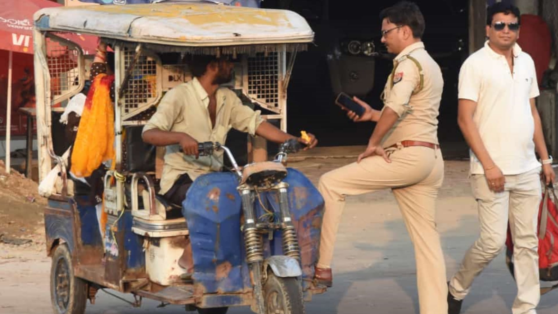 A police man takes action against an e rickshaw driver and leaves car.