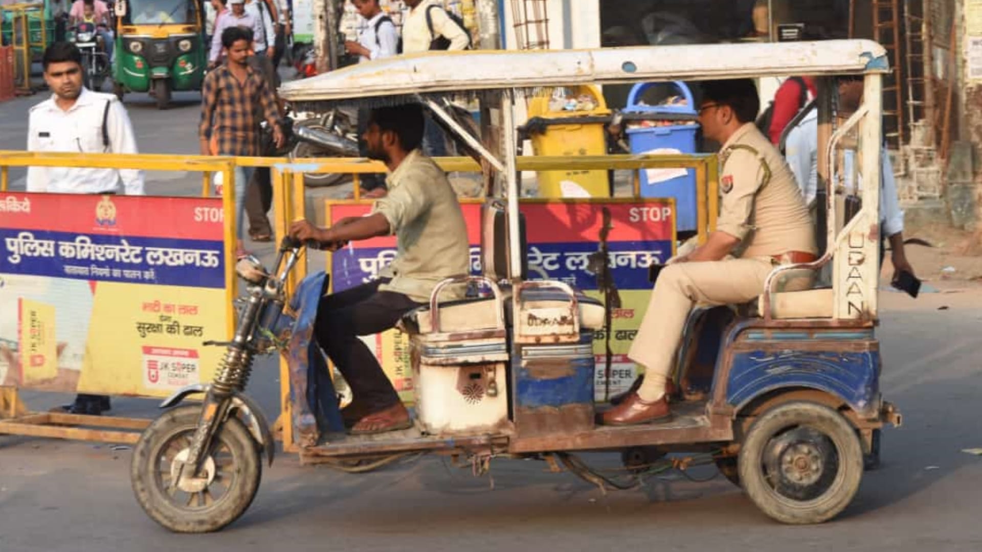 A police man takes action against an e rickshaw driver and leaves car.