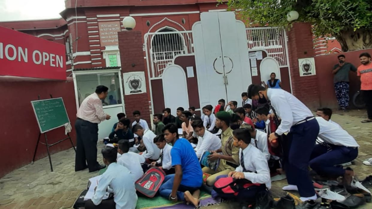 Teachers made classroom on road because of shifting of school.