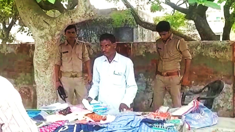 man sells clothes by handcart under the police protection in etah