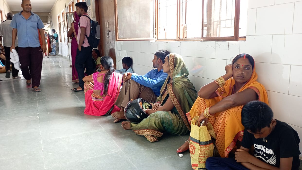 Patients wait their turn sitting on the floor
