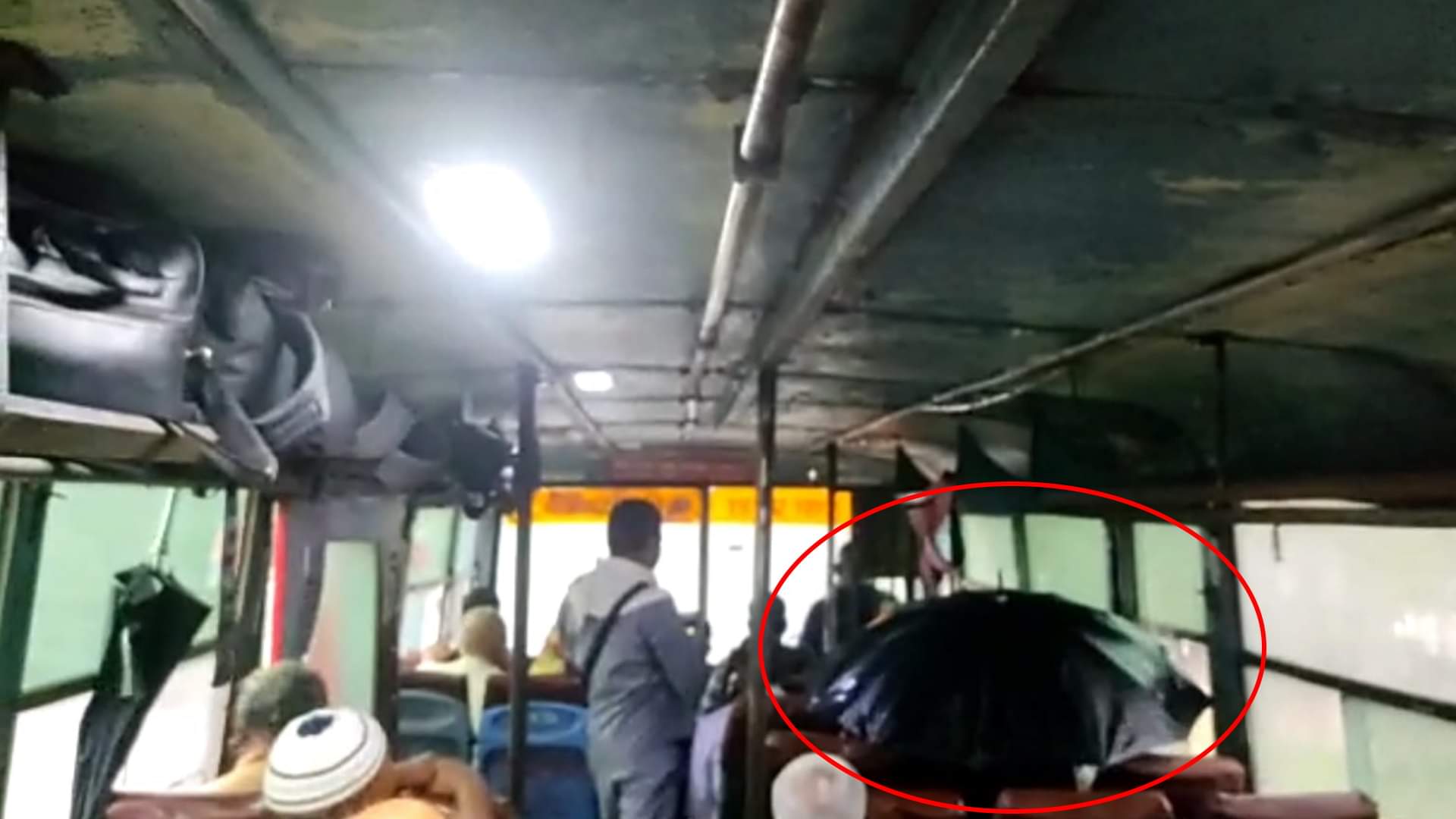 छाता लगाकर सफर करते यात्री।