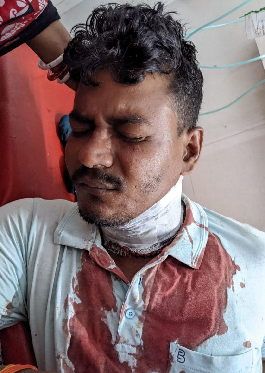 The shopkeeper hit the customer's shoulder with a sharp weapon