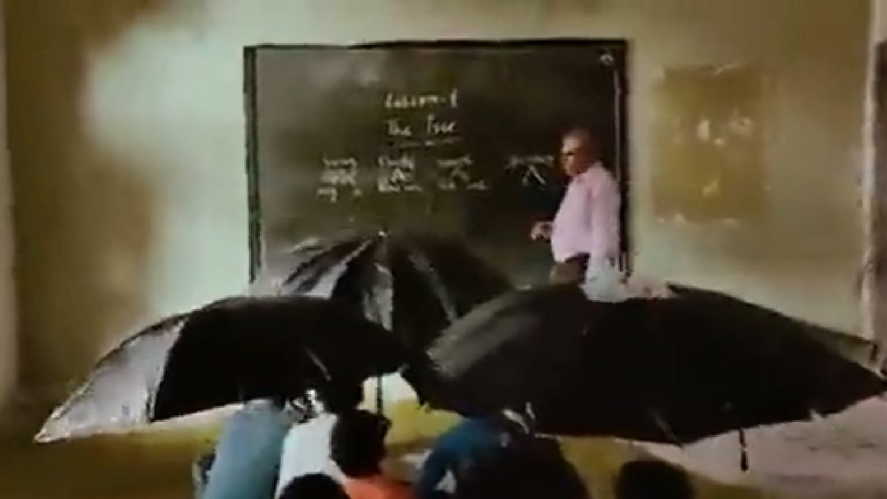 Picture depicting the plight of Seoni's school, children forced to study under umbrella in class