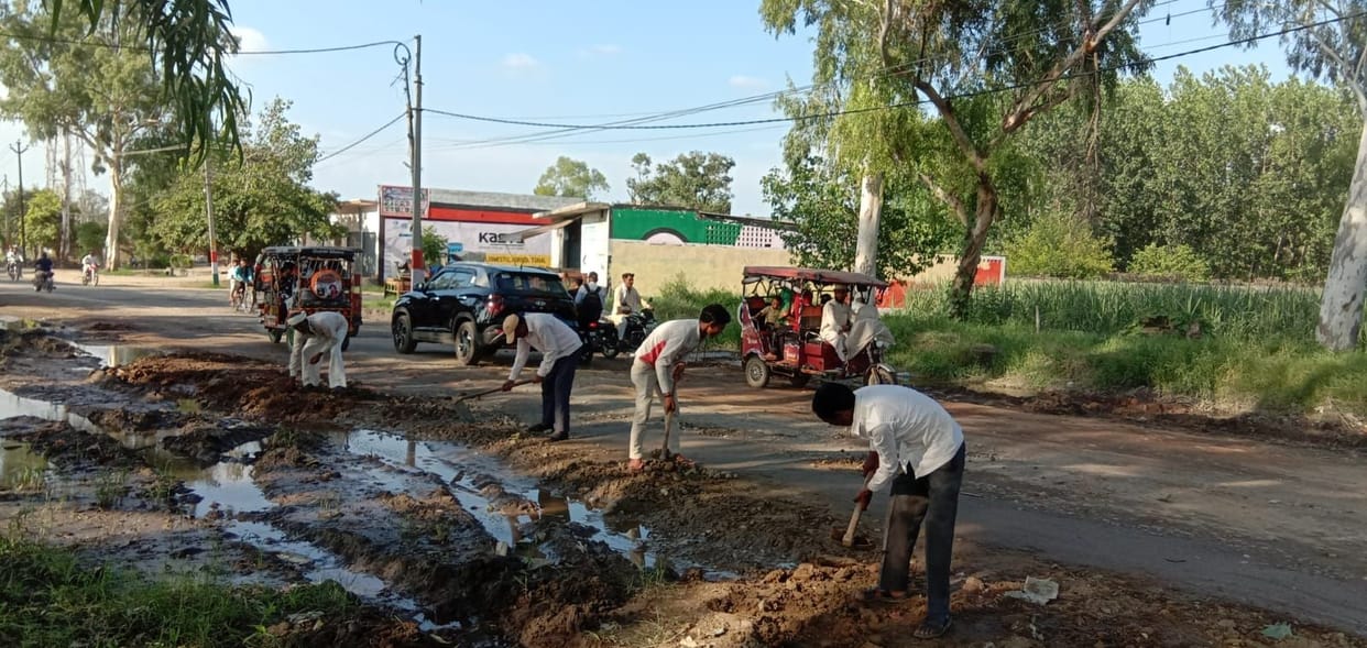 Workers engaged in filling potholes in Bhaisi village for the second day