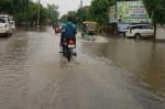 आगरा रोड पर बारिश के भरे पानी से निकलते वाहन ।संवाद