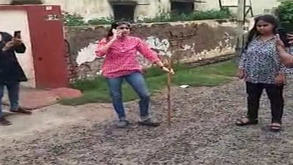 woman beat the guard with stick on road in Agra