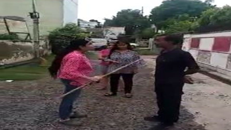 woman beat the guard with stick on road in Agra