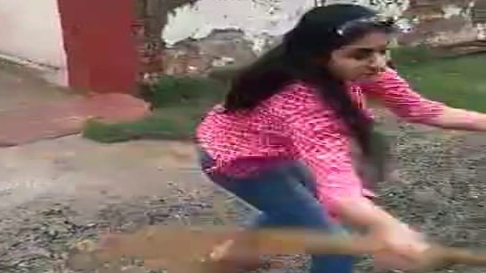 woman beat the guard with stick on road in Agra