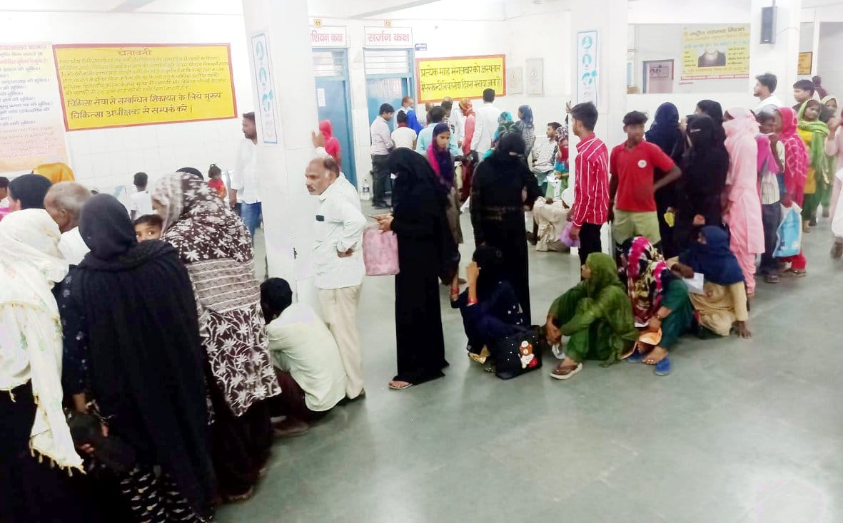 Crowd of patients in district hospital, no seating available