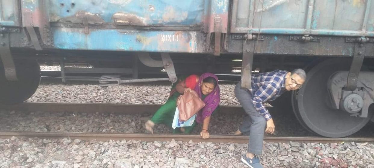 Passengers coming out from under the goods train risking their lives