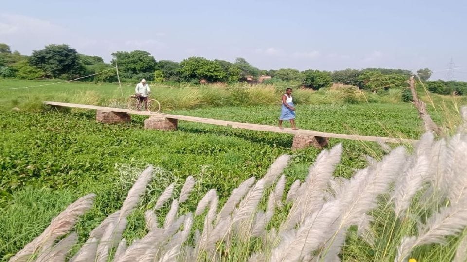 villagers cross the Arind river with the help of electric poles in mainpuri
