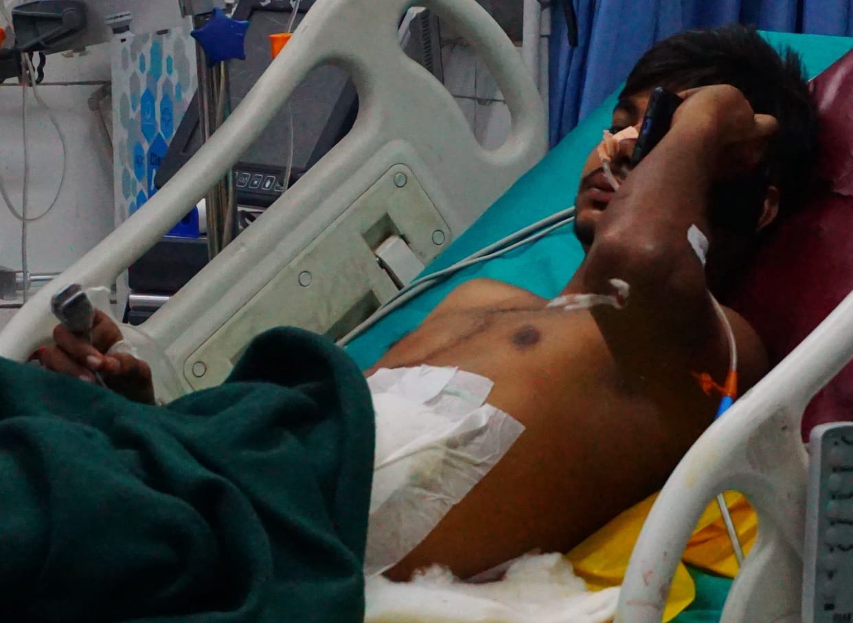 young man standing on the bank of the river got shot, injured