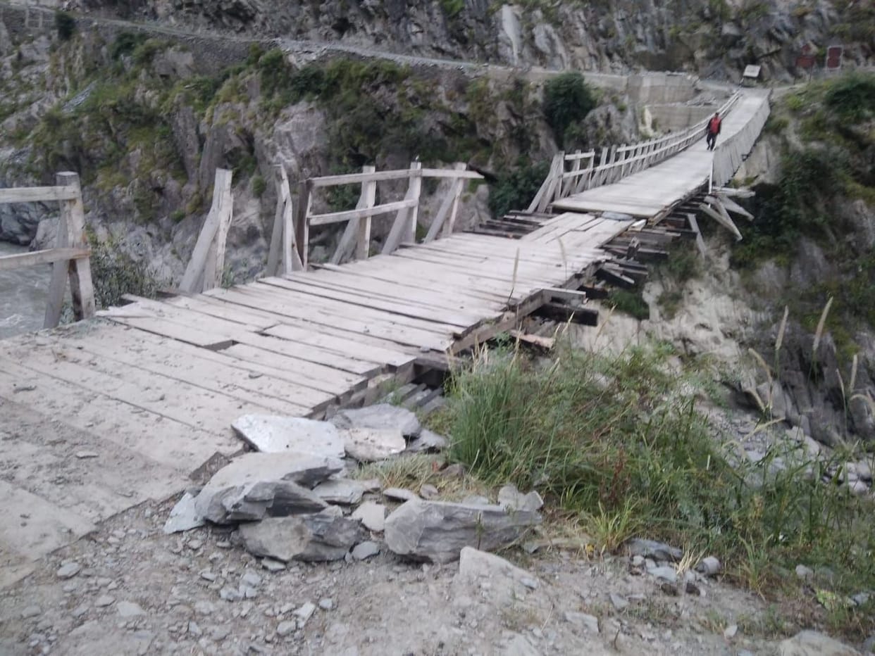 Villagers crossing the bridge risking their lives