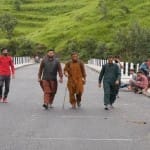 पुंछ एलओसी पर बने पुल से गुजरते लोग