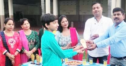 पलिया में निबंध प्रतियोगिता के विजेताओं को पुरस्कृत करते बीईओ।