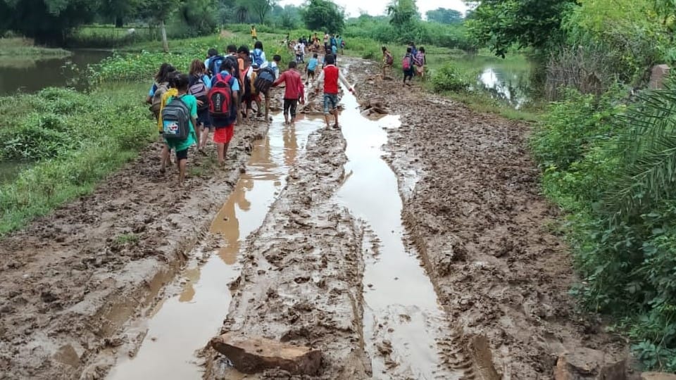 Damoh: School children walking barefoot through muddy road