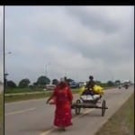 बच्ची को बिठाकर गाड़ी खींचती महिला
