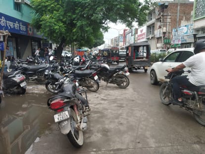 शहर के सर्कुलर रोड पर बैंक के बाहर बीच रास्ते में खड़े दो पहिए वाहन ।