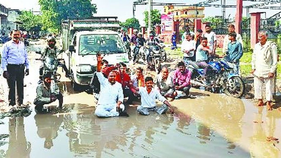 Unique demonstration People sitting in water in protest against potholes on the roads in agra