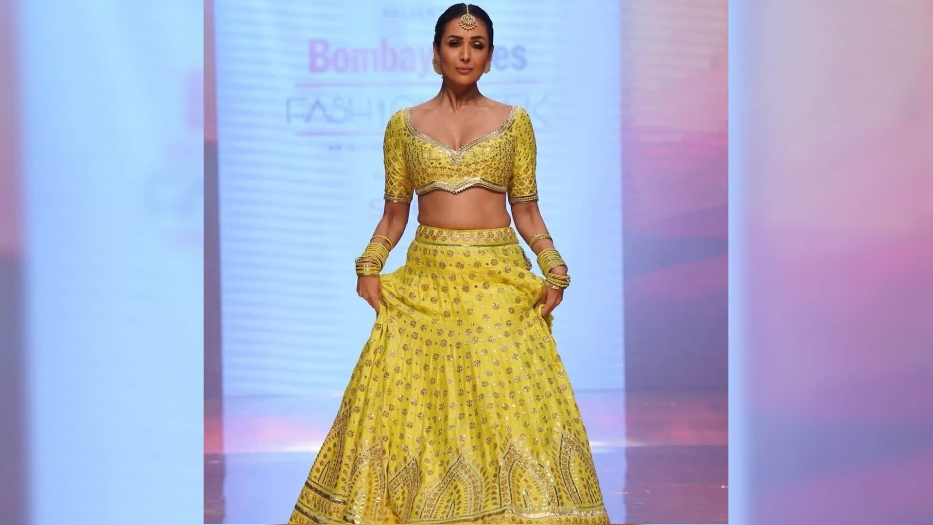 malaika arora walk on ramp in yellow lehenga with backless blouse totally traditional style