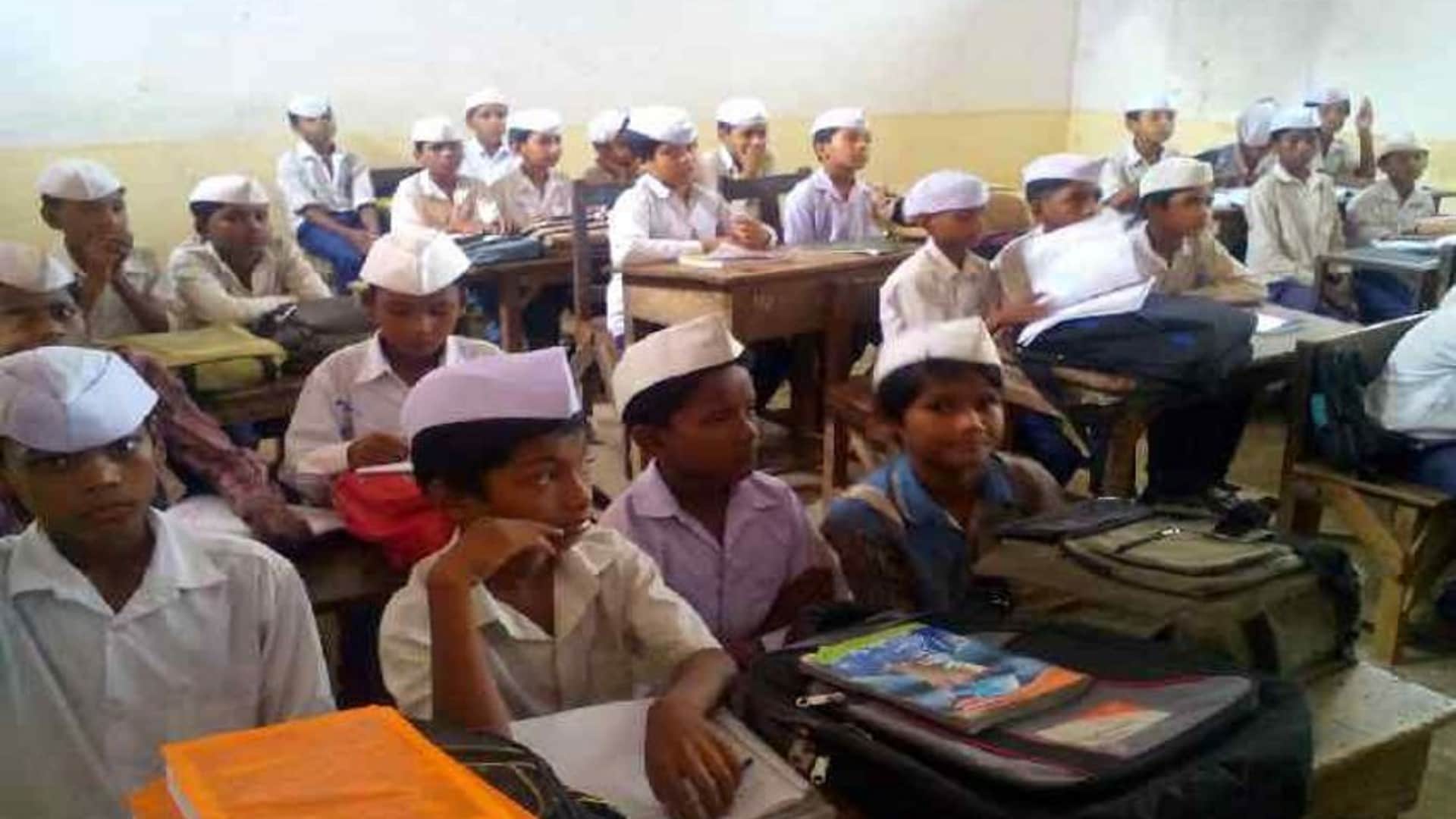 टोपी लगाकर पढ़ाई करते हैं छात्र