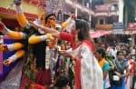दुर्गा पूजा के अंतिम दिन कालीबाड़ी मंदिर में माथा टेकती महिला।