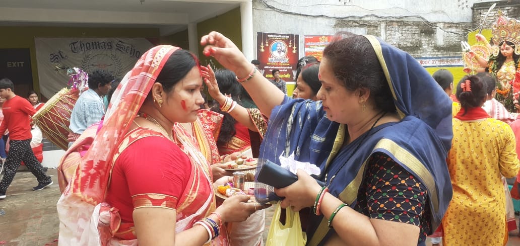 Bengali women applied vermilion to each other to wish happiness
