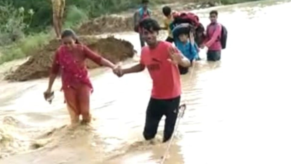 पानी में फंसे बच्चों को लोगों ने रस्सी के सहारे निकाला।
