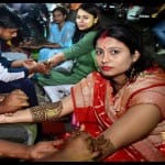 बाजार मेहंदी लगवाती महिलाएं