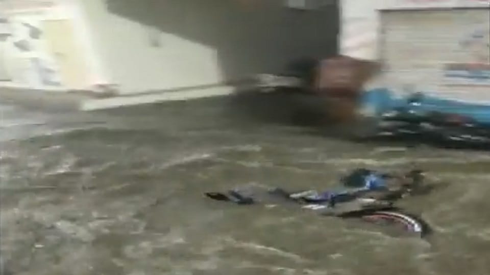 Hyderabad man With his two-wheeler washed away in flooded street