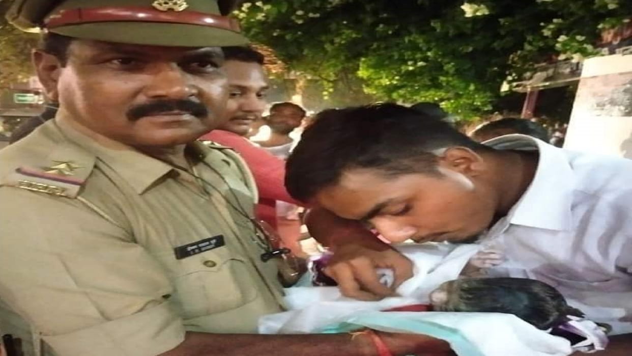 Policemen help to a woman suffering from labor pain on the road in varanasi