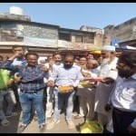 लड्डू बांटते व्यापारी