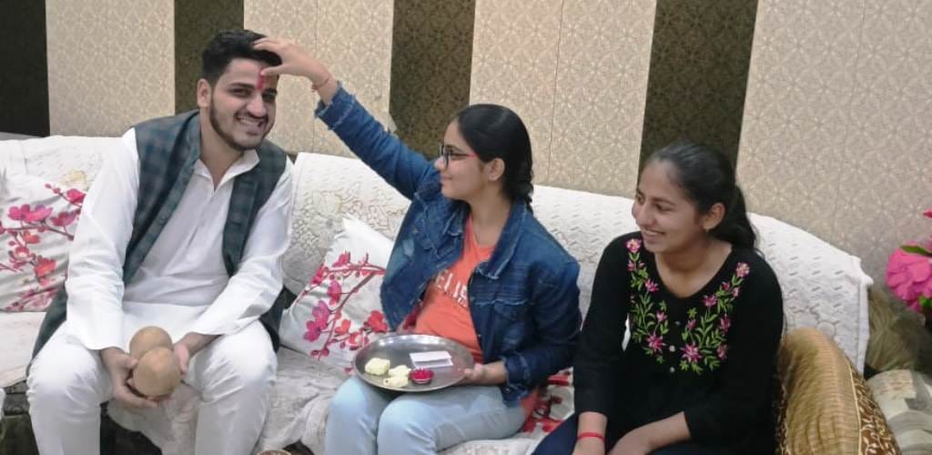 Sisters wish their brothers long life by doing tilak