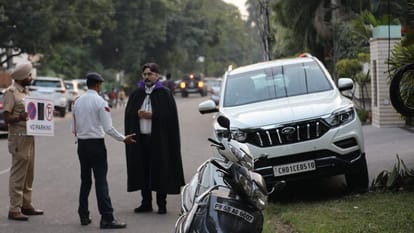 चंडीगढ़ में बाहर खड़ी गाड़ियों का चालान काटते पुलिसकर्मी।