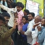खाद के लिए कतार में लगे किसानों को समझाइश देते पुलिसकर्मी
