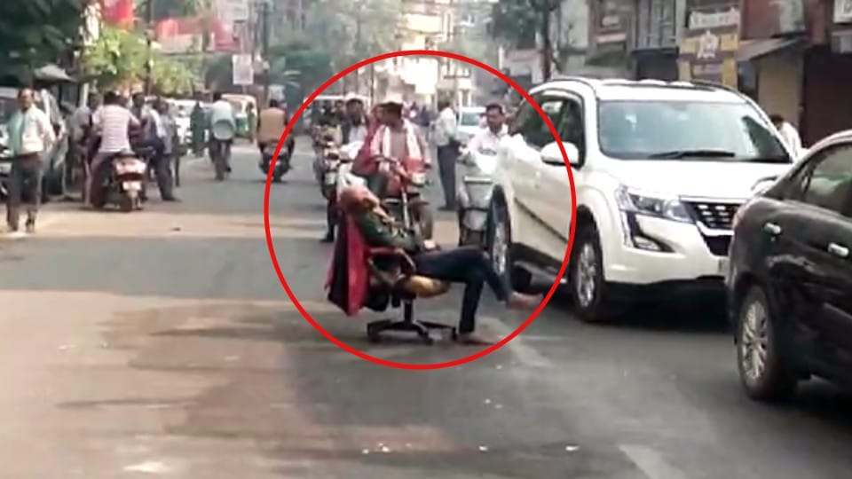 Pavement shopkeeper sat on the middle road making a chair and spilled the jam