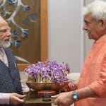 पीएम नरेंद्र मोदी को केसर का गुलदस्ता भेंट करते एलजी सिन्हा