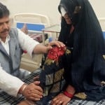 अस्पताल में भर्ती बुजुर्ग महिला के पैर दबाते मंत्री तोमर।