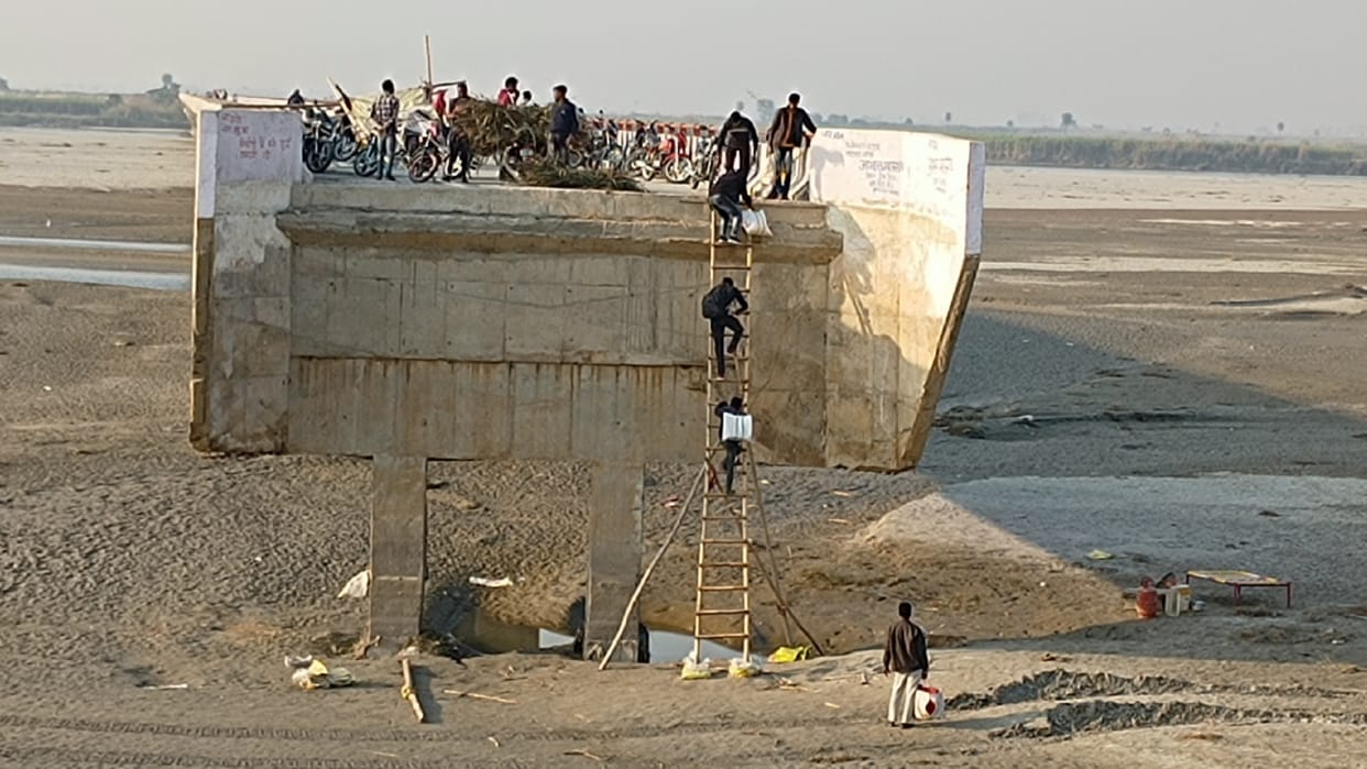 BIJNOR: villagers are crossing the bridge by putting a ladder after breaking the approach road
