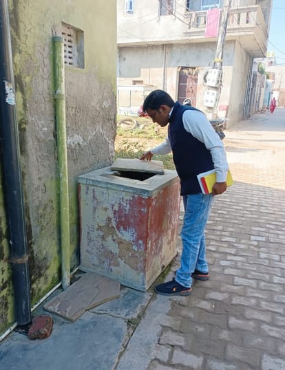 फोटो 02  पानी में लारवा की जांच करता स्वास्थ्य विभाग का कर्मचारी।