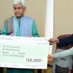 एलजी मनोज सिन्हा चेक सौंपते हुए
