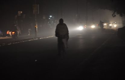 घंटाघर पर देर रात बंद पड़ी स्ट्रीट लाइटों के कारण छाए अंधेरे के बीच से गुजरता साइकिल सवार।