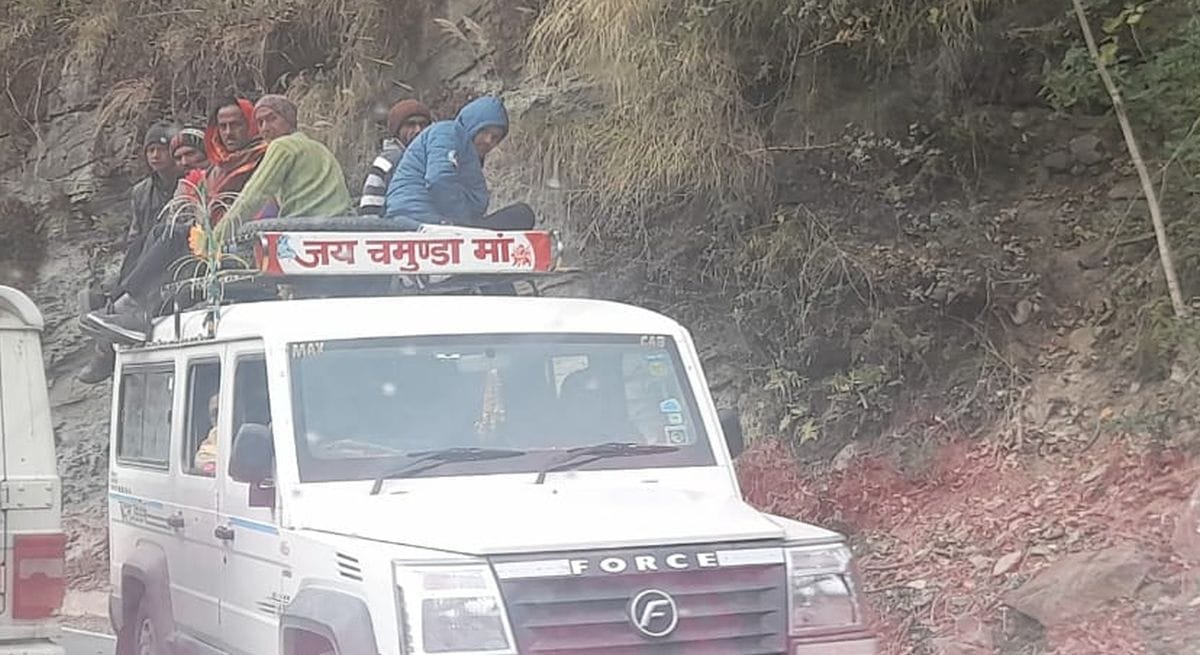 Passengers being seated on the roof of a taxi