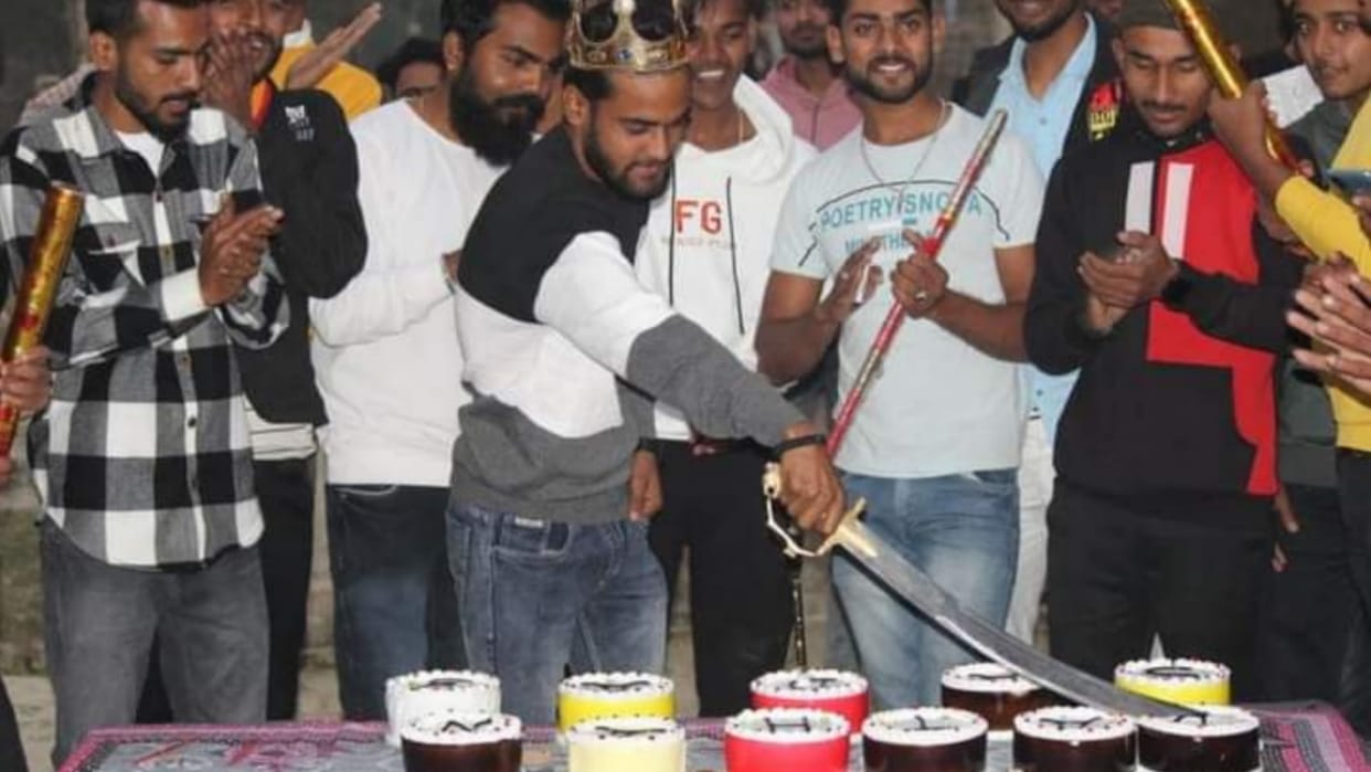 A man cuts the cake with a sword in Sareni in Raebareli.