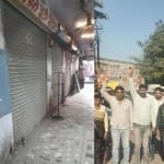 बंद दुकानें व प्रदर्शन करते व्यापारी।